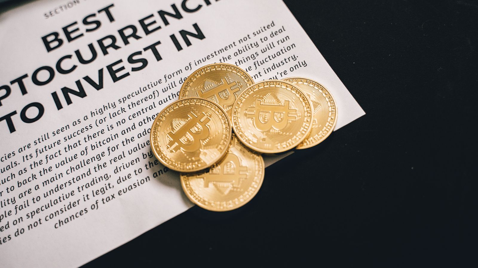 Close-up of Bitcoin coins on investment document promoting cryptocurrencies.