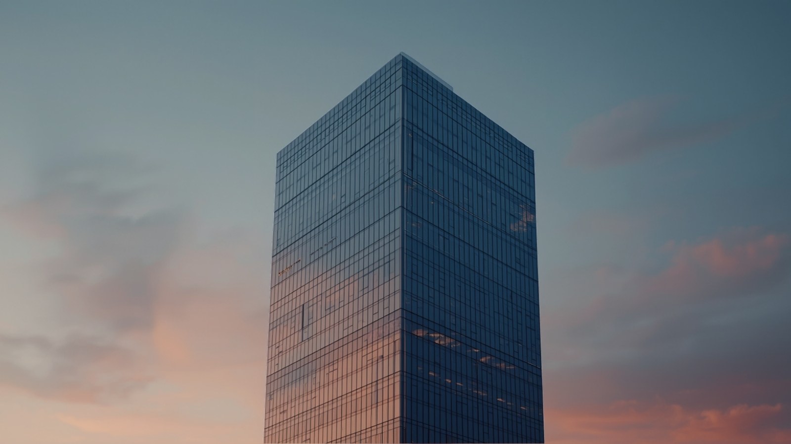 Glass office tower against a pastel dusk sky
