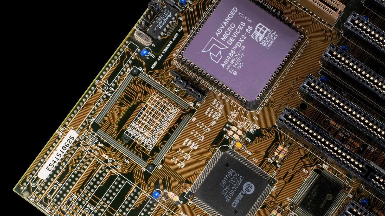 Detailed view of a vintage motherboard with microchips and circuits, showcasing retro technology.