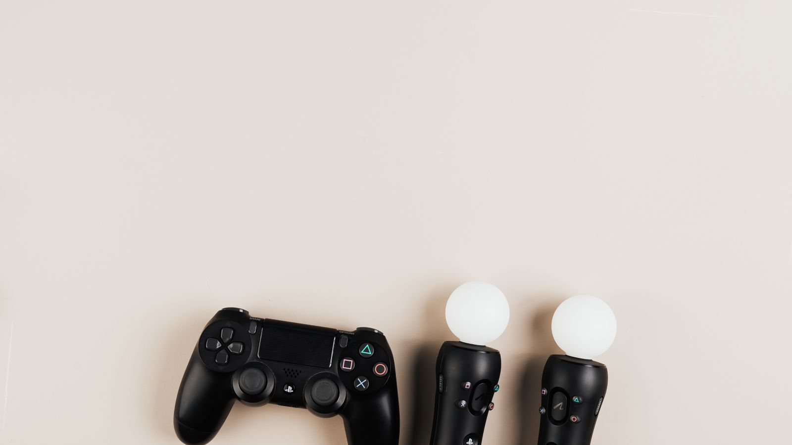 Black gaming controllers arranged on a light background with ample copy space.