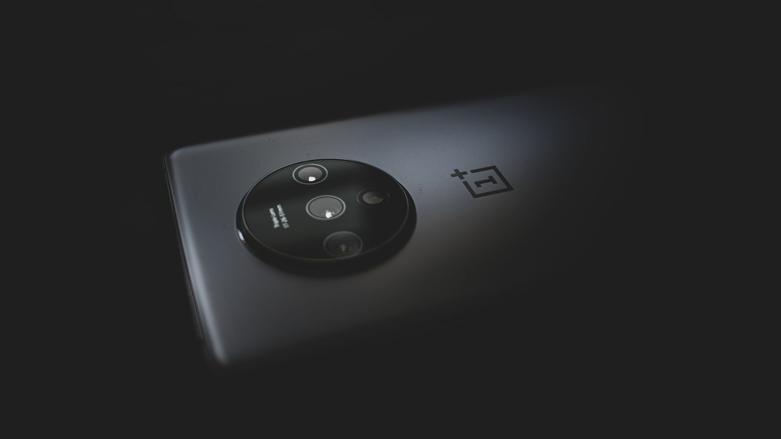 Detailed close-up of a modern smartphone camera against a dark background.