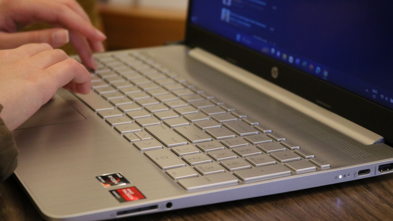 Hands typing on a silver laptop keyboard, showcasing productivity and technology.