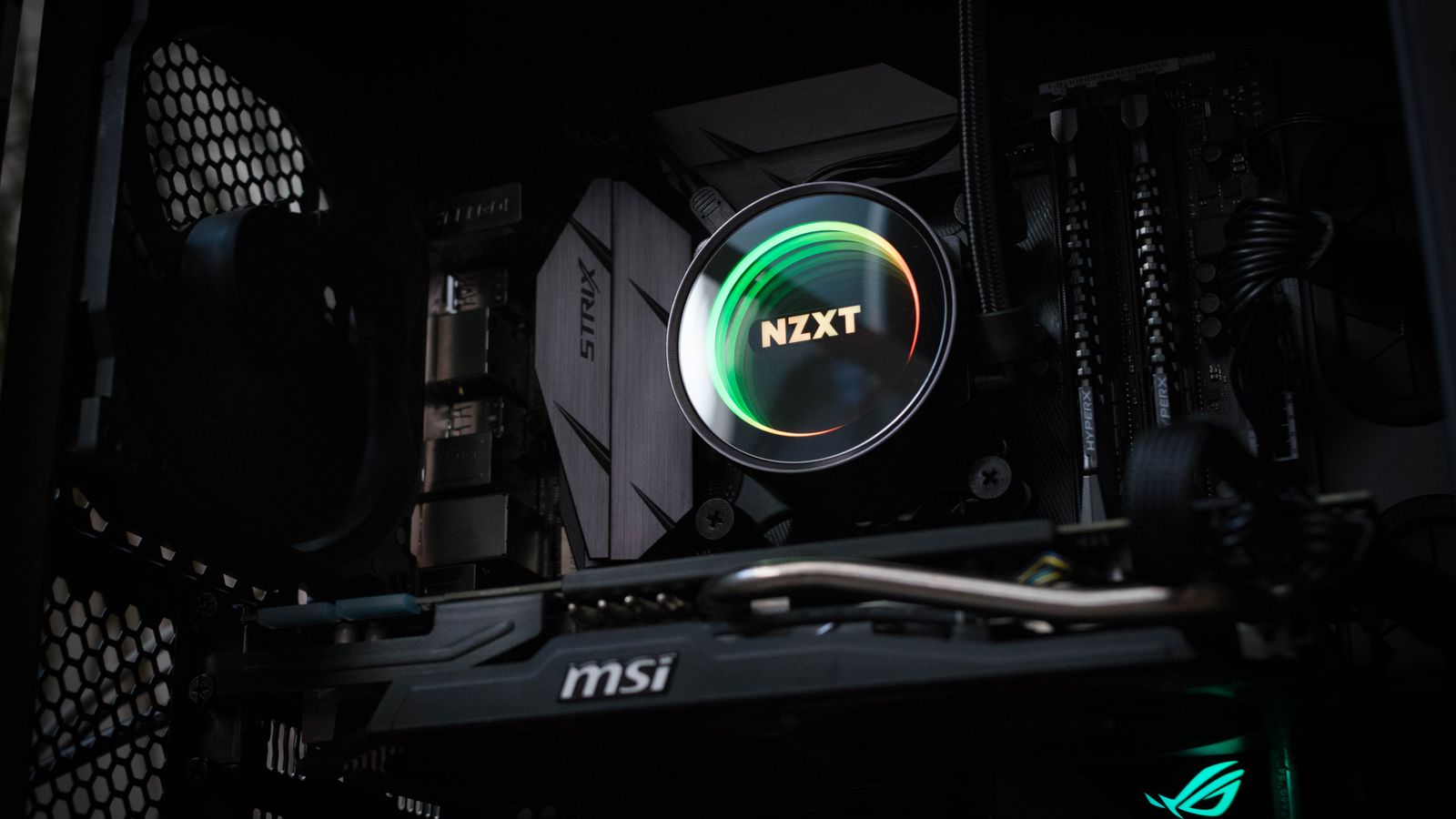 Detailed view of an illuminated NZXT cooler inside a gaming PC showcasing advanced components.