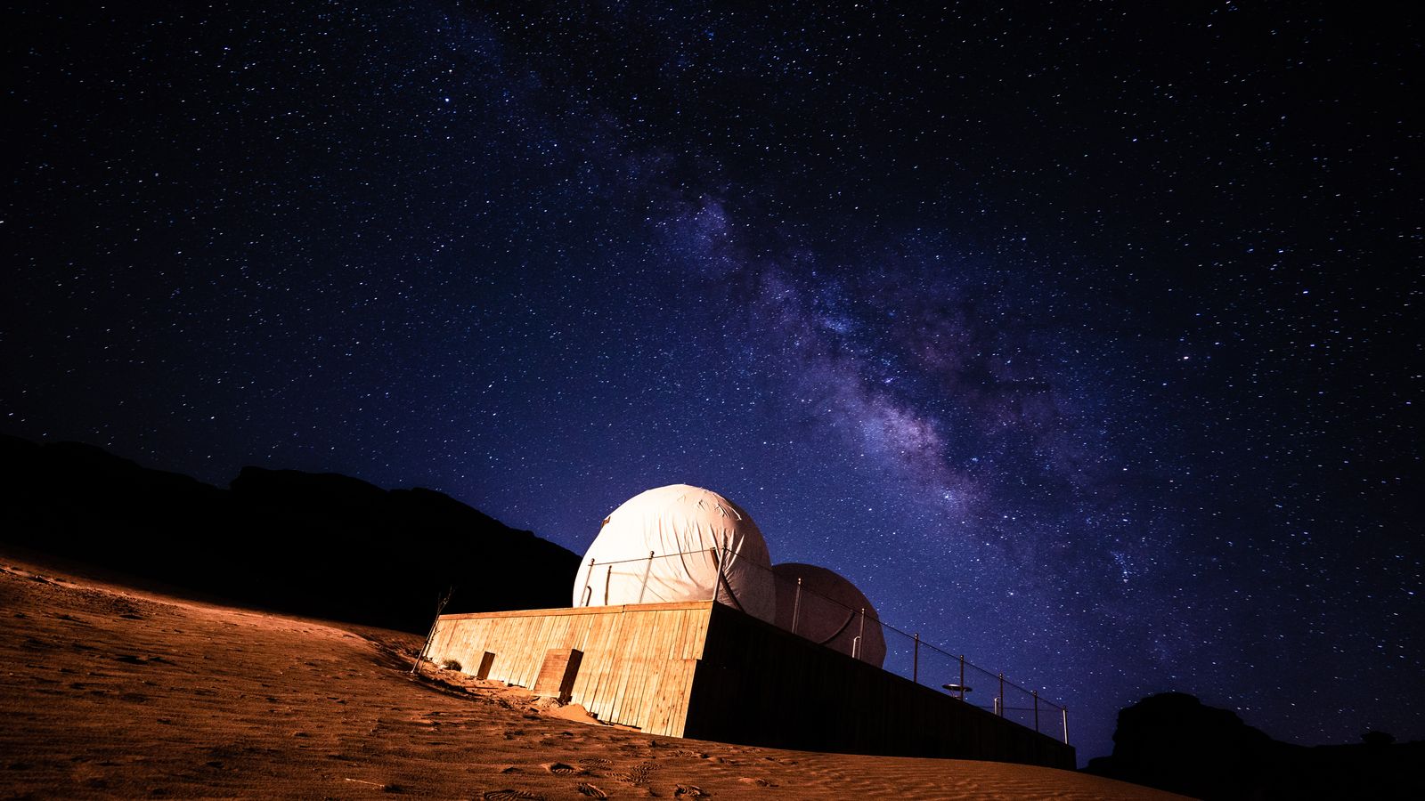 Stunning view of the Milky Way galaxy above a desert observatory under a starry night.