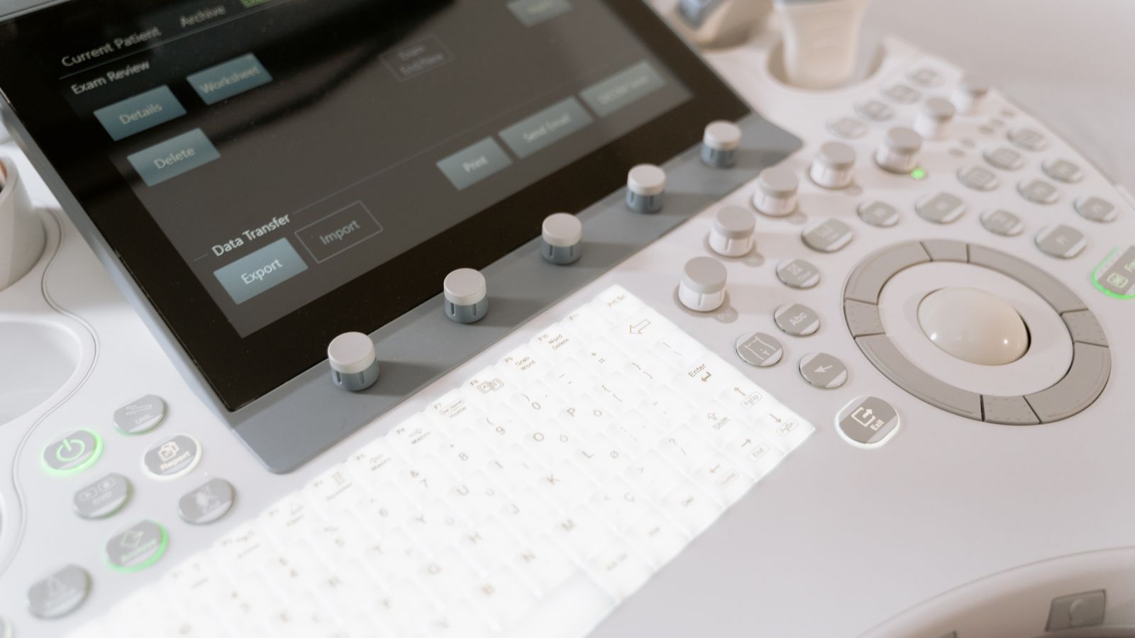 Detailed view of a medical ultrasound machine control panel with buttons and screen.