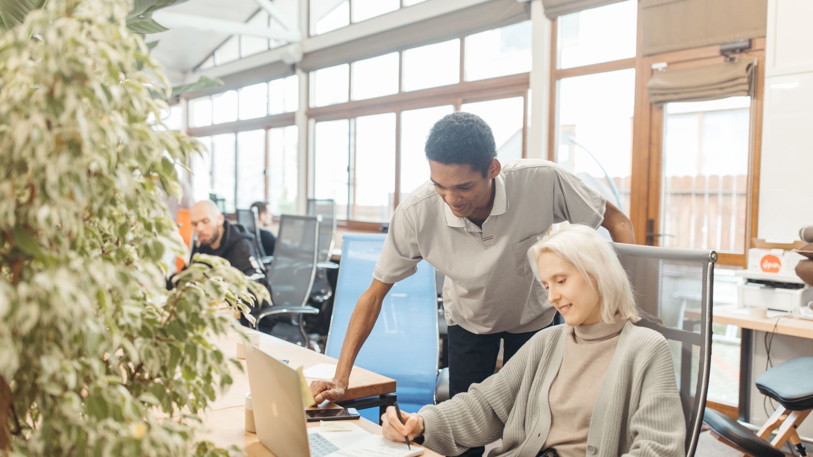 A diverse team working together in a modern office space, showcasing teamwork and collaboration.