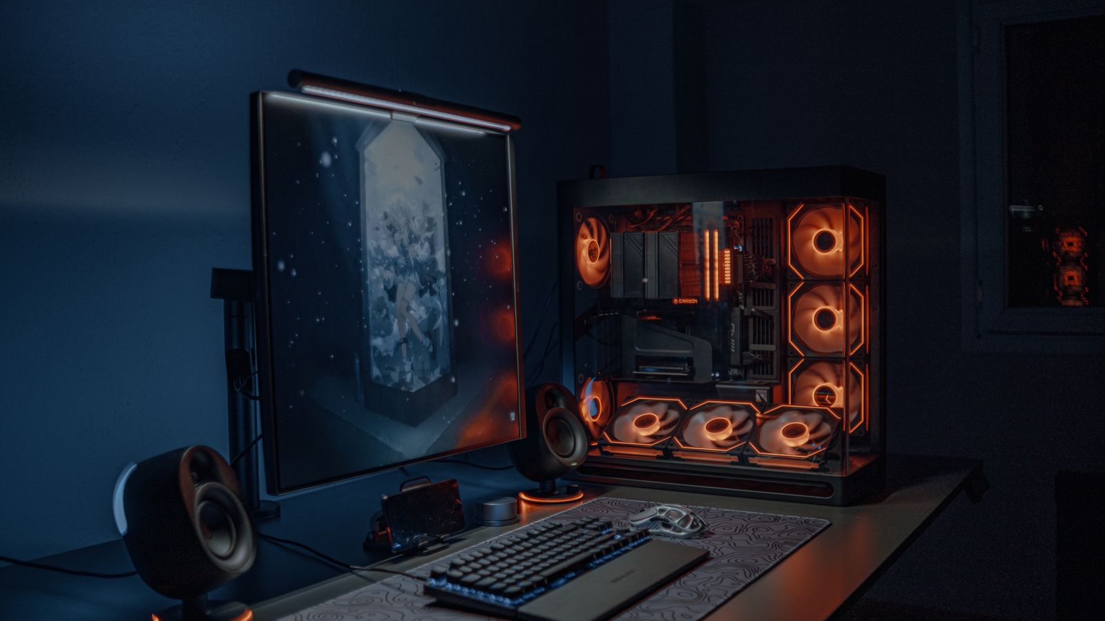 A sleek gaming PC setup with LED lights, monitor, and keyboard in a dimly lit room.