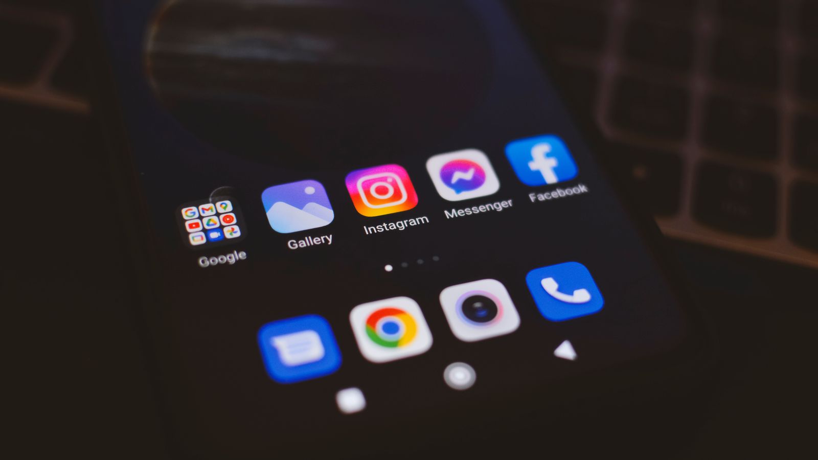A smartphone displaying popular social media apps in a dimly lit environment, perfect for tech and communication themes.