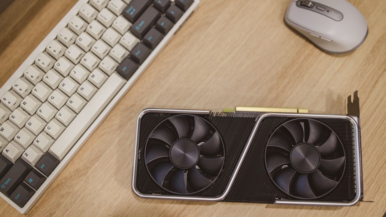 Top view of a desktop with a keyboard, mouse, and graphics card.
