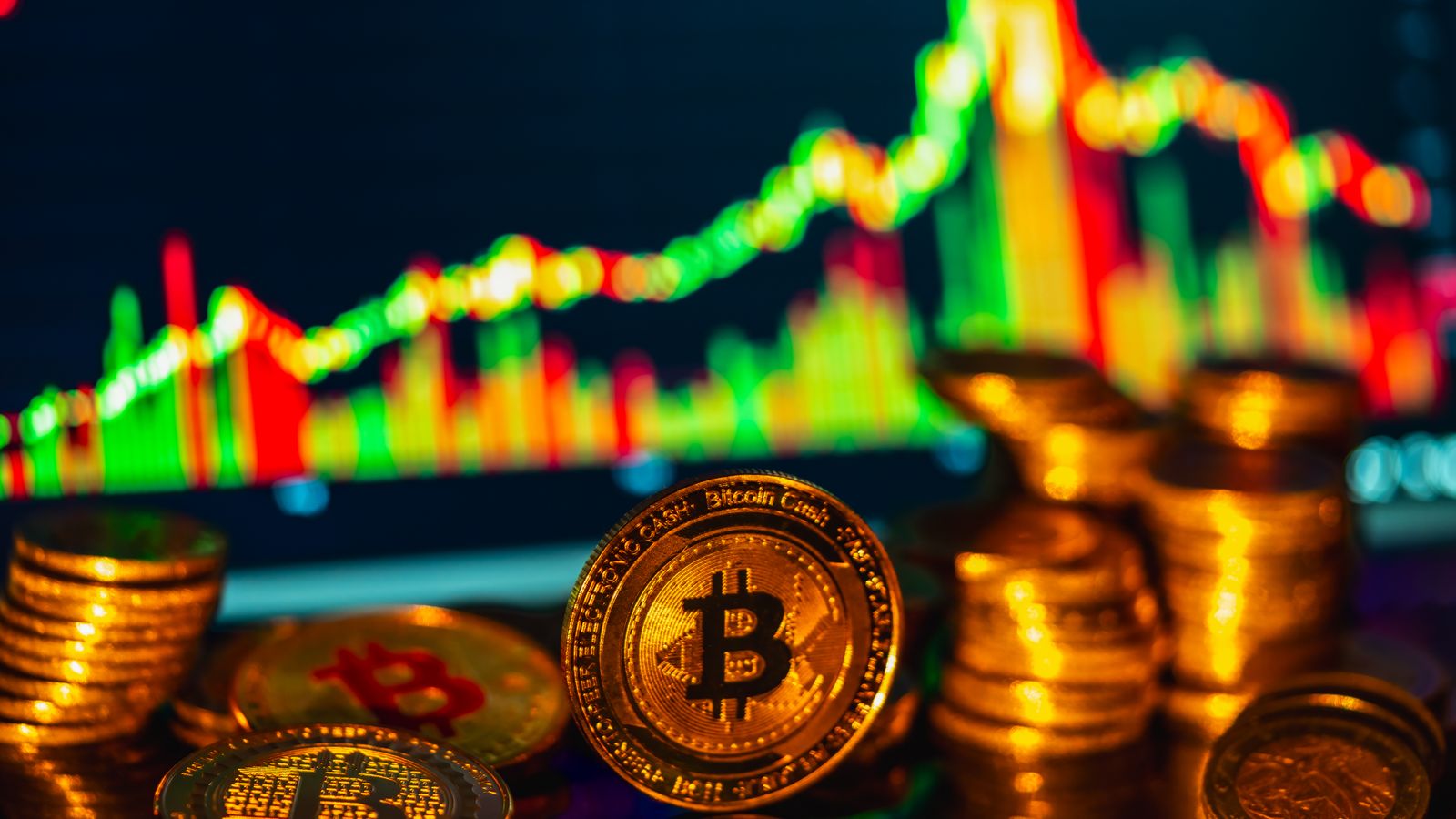 Golden bitcoins stacked in foreground with a financial graph in the background, symbolizing digital investments.