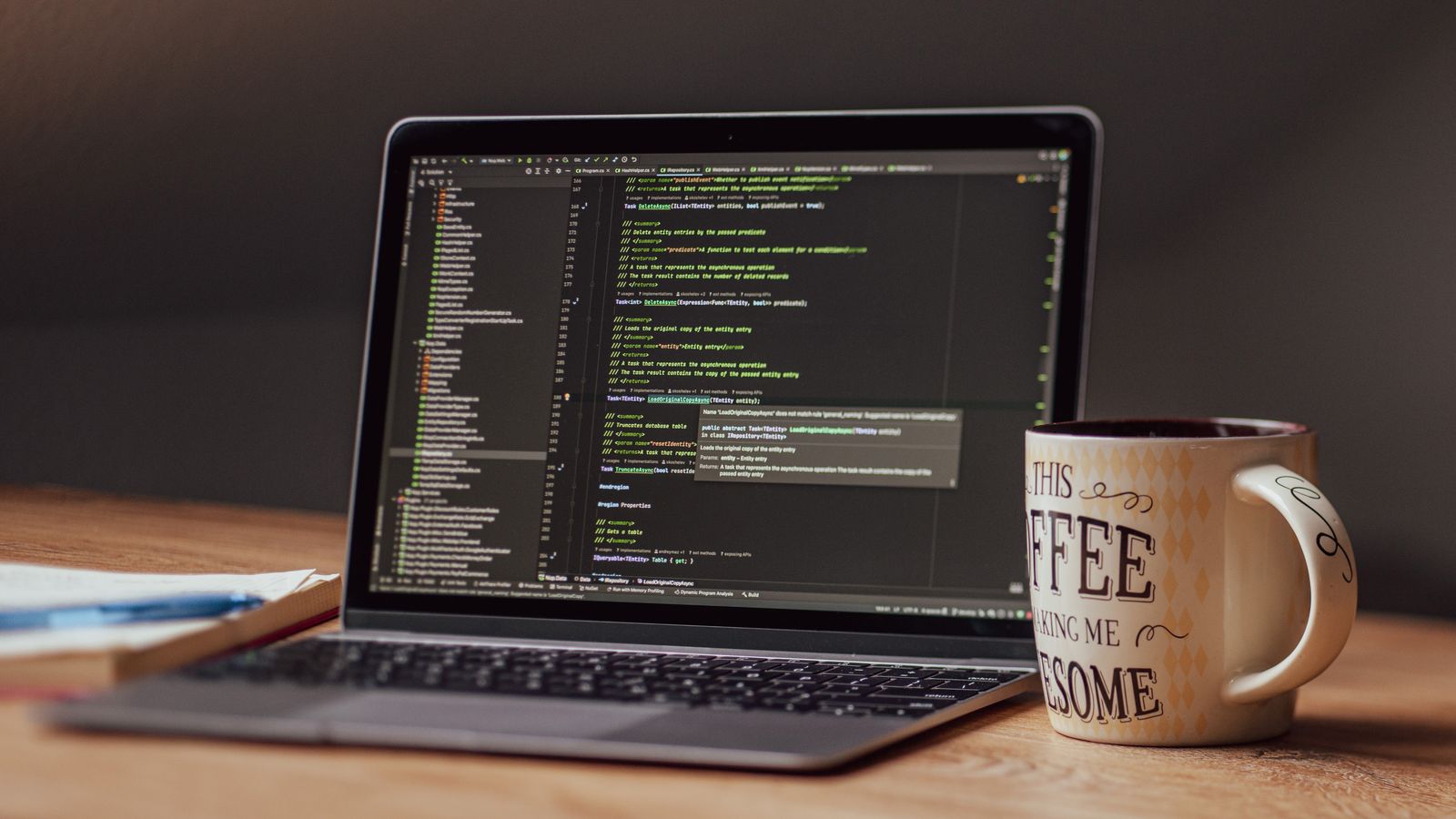 Laptop displaying code editor with coffee mug on desk, perfect for tech themes.