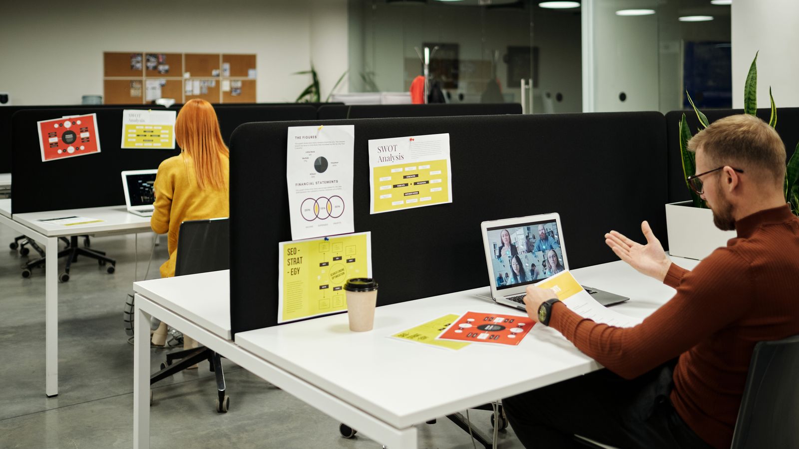Colleagues working and collaborating virtually at a stylish modern office workspace.
