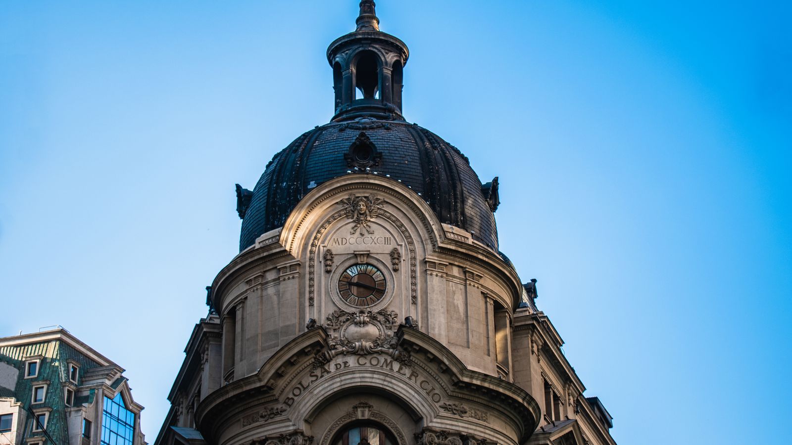 Low angle view of the iconic dome of the Santiago Stock Exchange building against a clear blue sky.