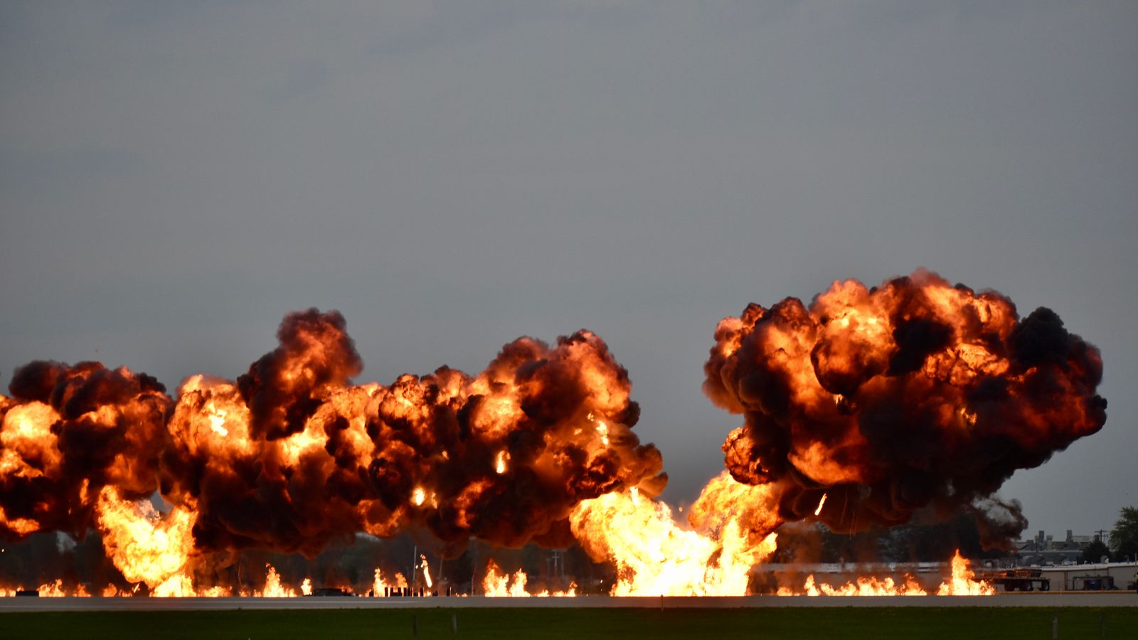 Dramatic explosion during airshow in Oshkosh, Wisconsin showcasing flames and smoke.