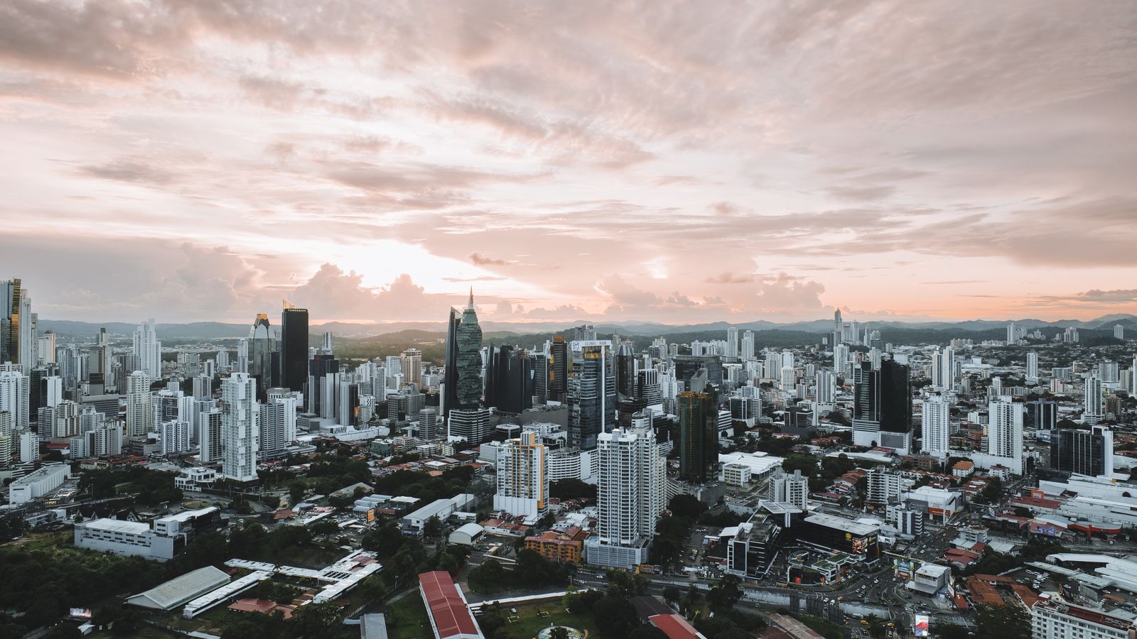 Dramatic aerial view of Panama City skyline during sunset showcasing modern skyscrapers.
