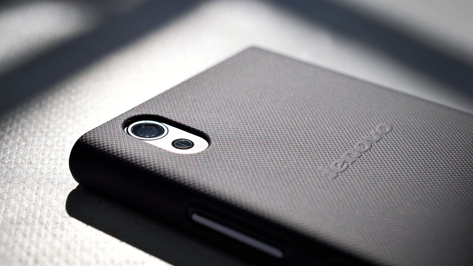 Detailed close-up view of a smartphone with a textured back cover emphasizing modern design and technology.