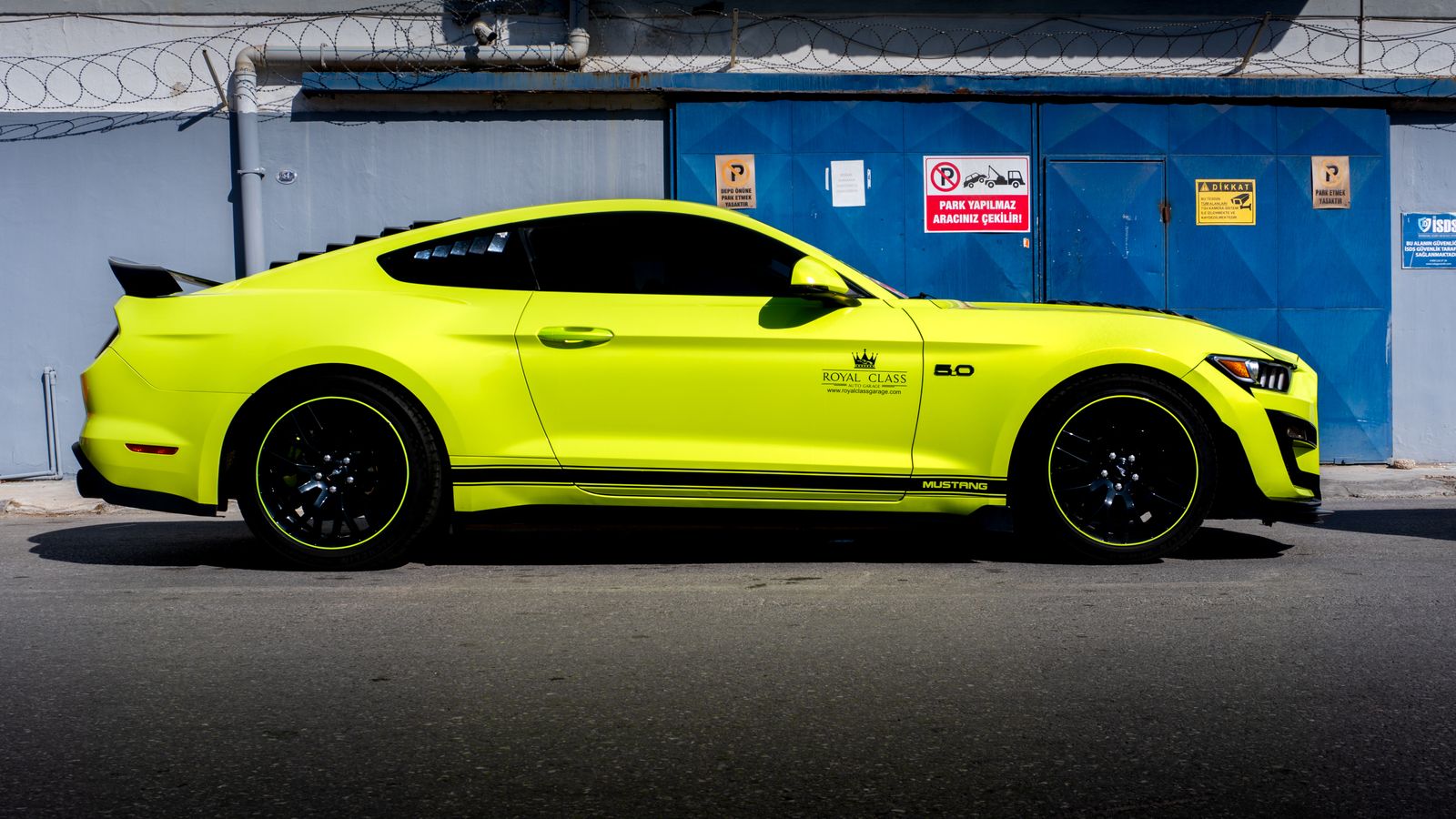 A sleek yellow sports car parked against an industrial backdrop in Türkiye.