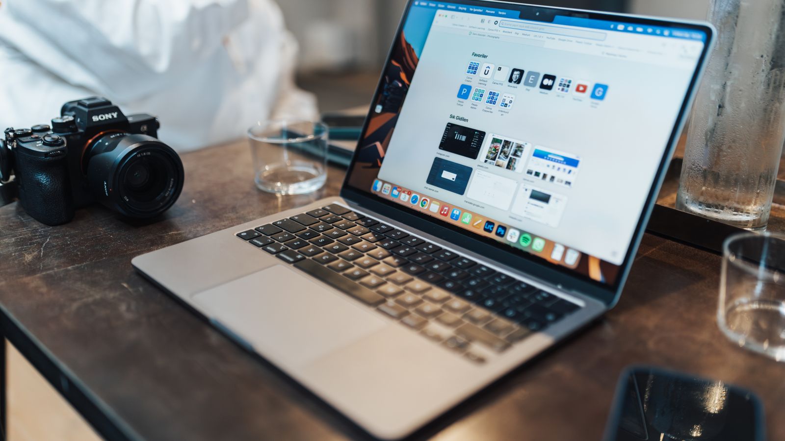 A sleek workspace featuring a laptop and camera, ideal for tech and photography themes.
