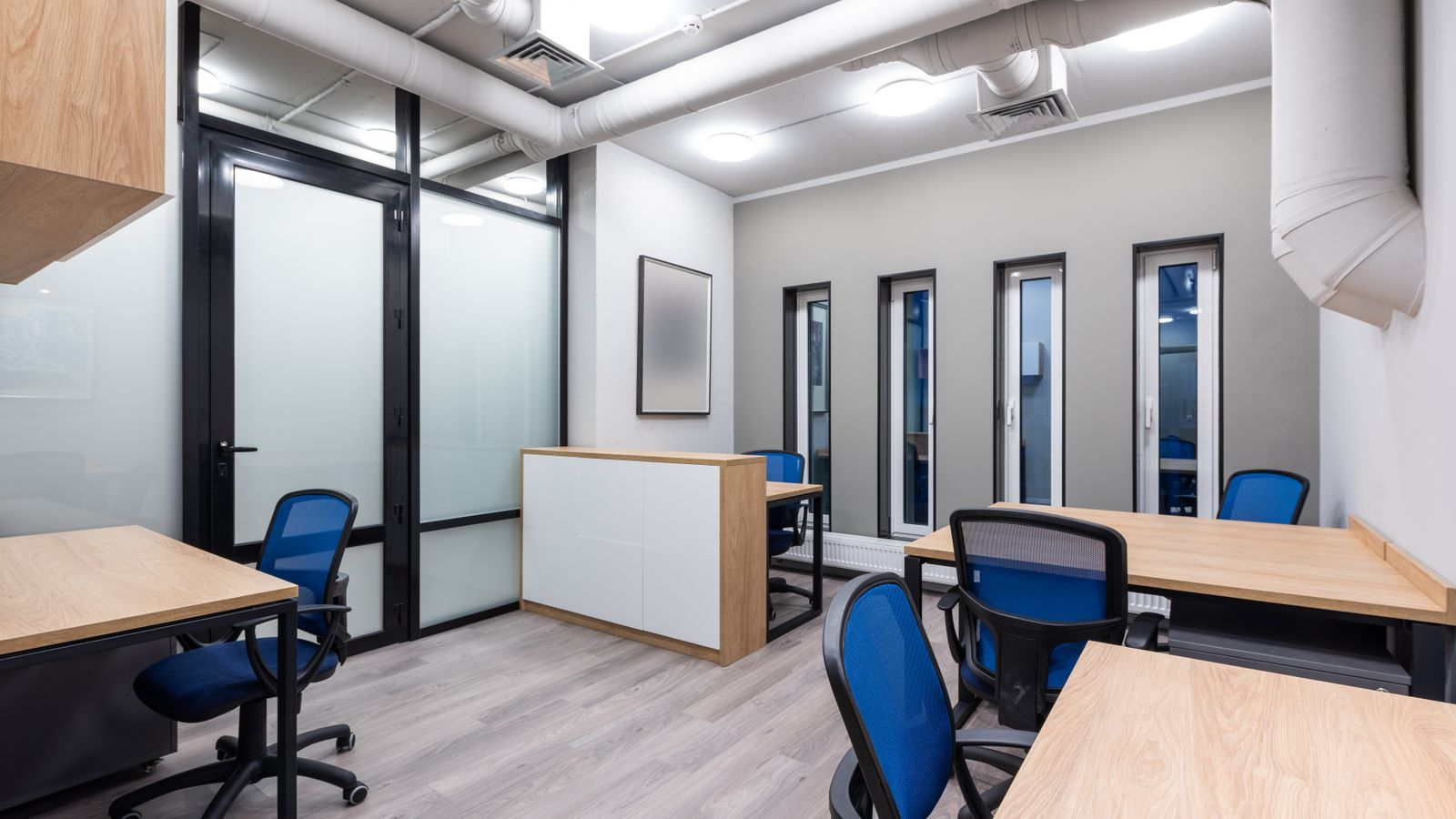 Interior of new contemporary spacious workplace with wooden desks and blue office chairs