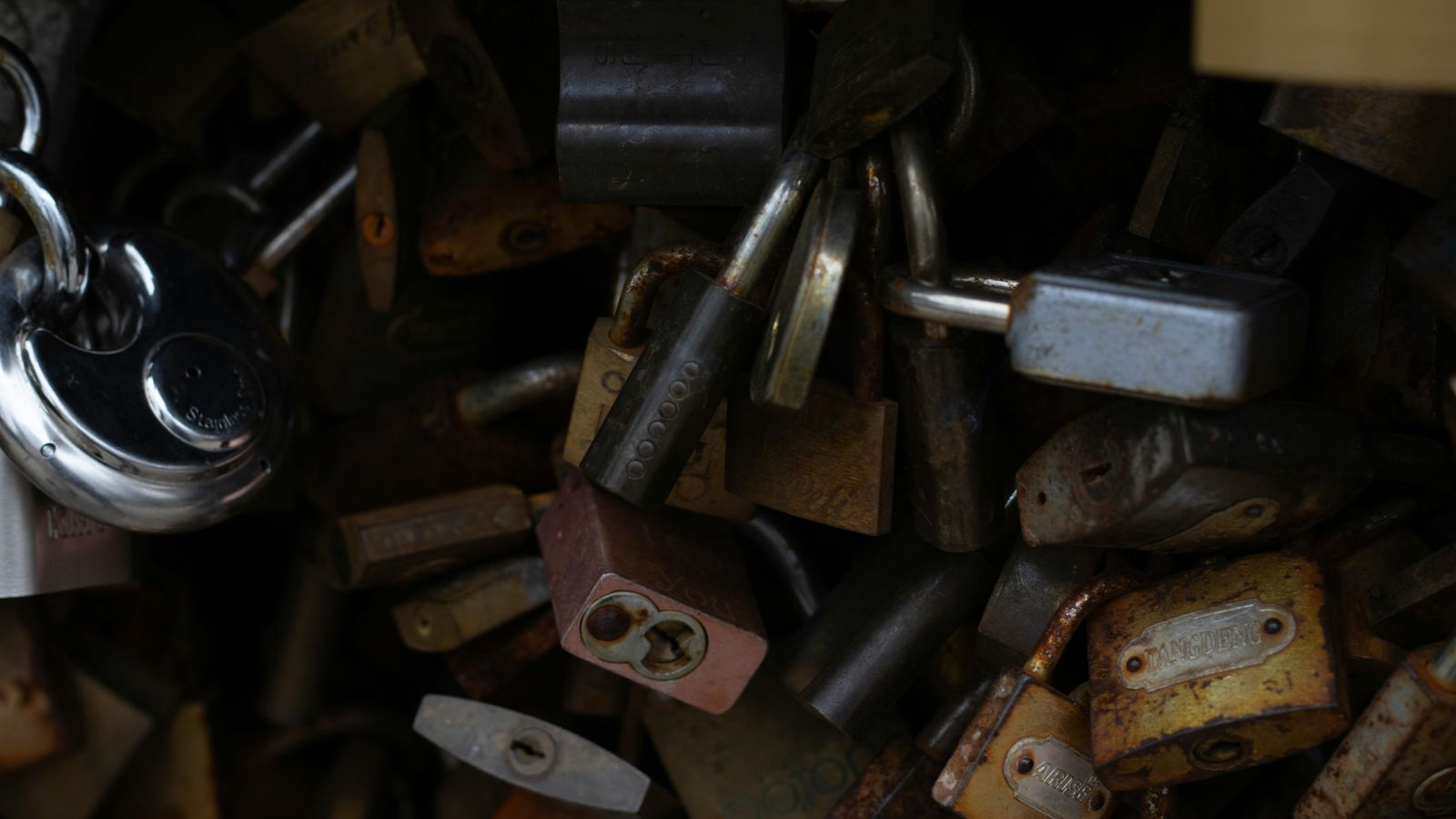 Image showing a pile of rustic and shiny padlocks, symbolizing security.