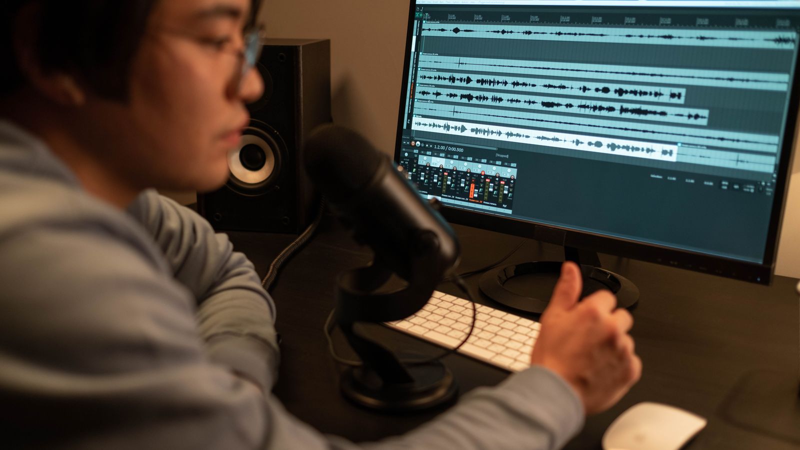 Sound engineer working on audio editing with a computer in a recording studio.