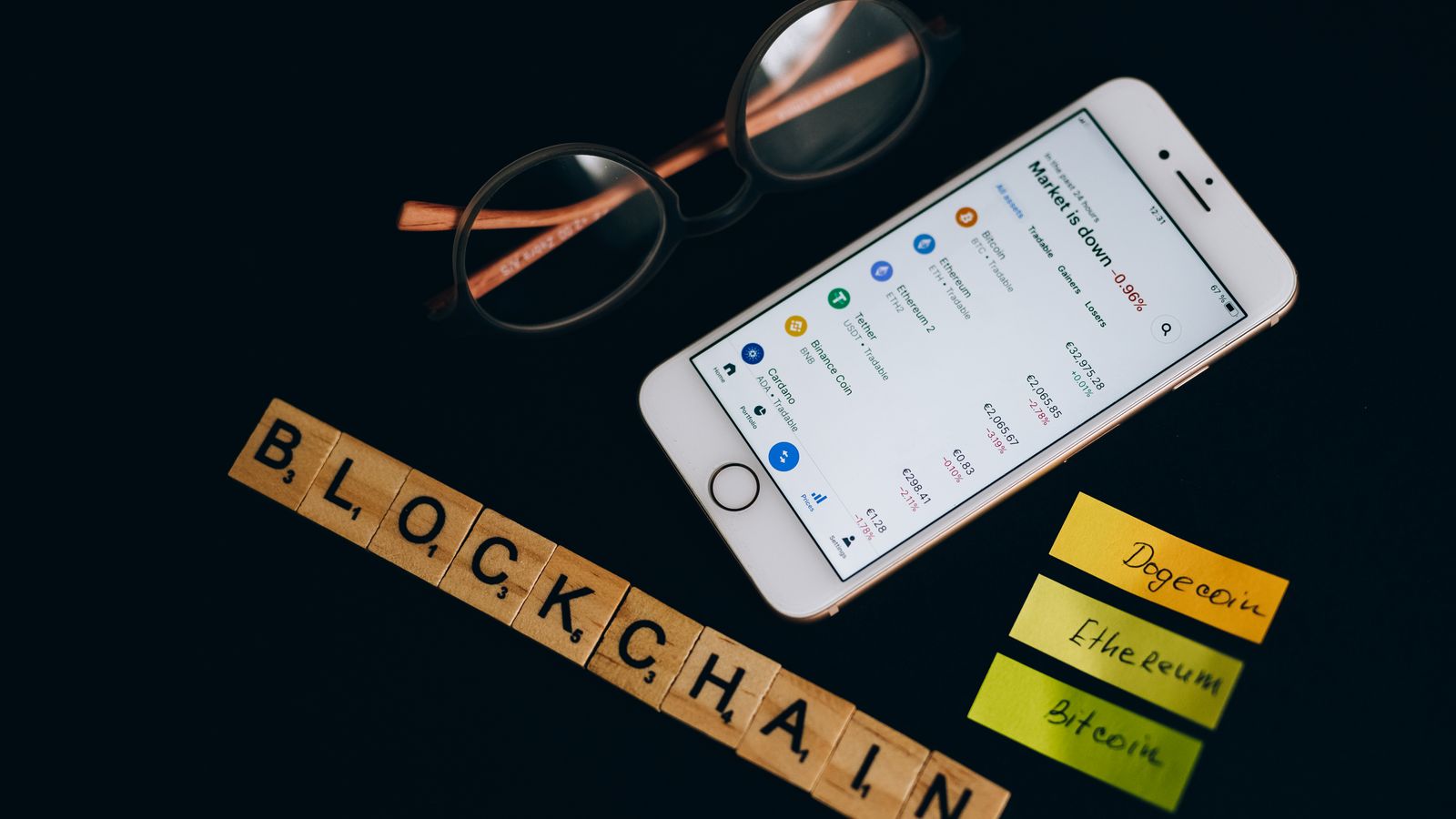 Smartphone displaying cryptocurrency market data alongside blockchain concept elements.
