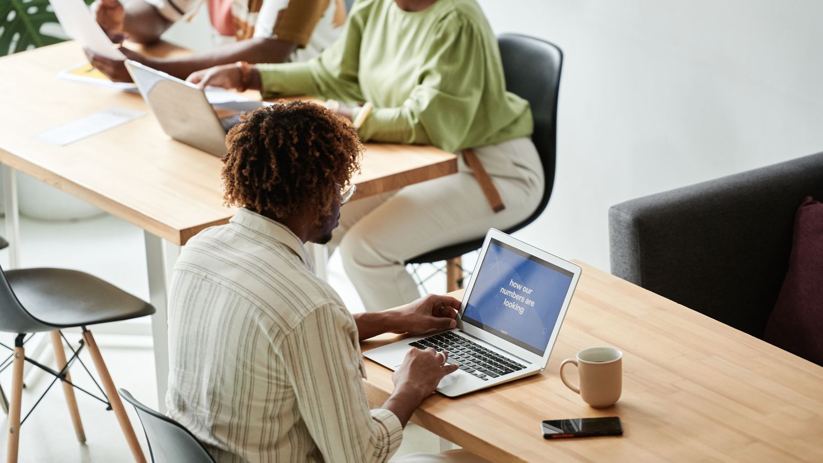 Group of colleagues working together in a bright, modern meeting room setting.