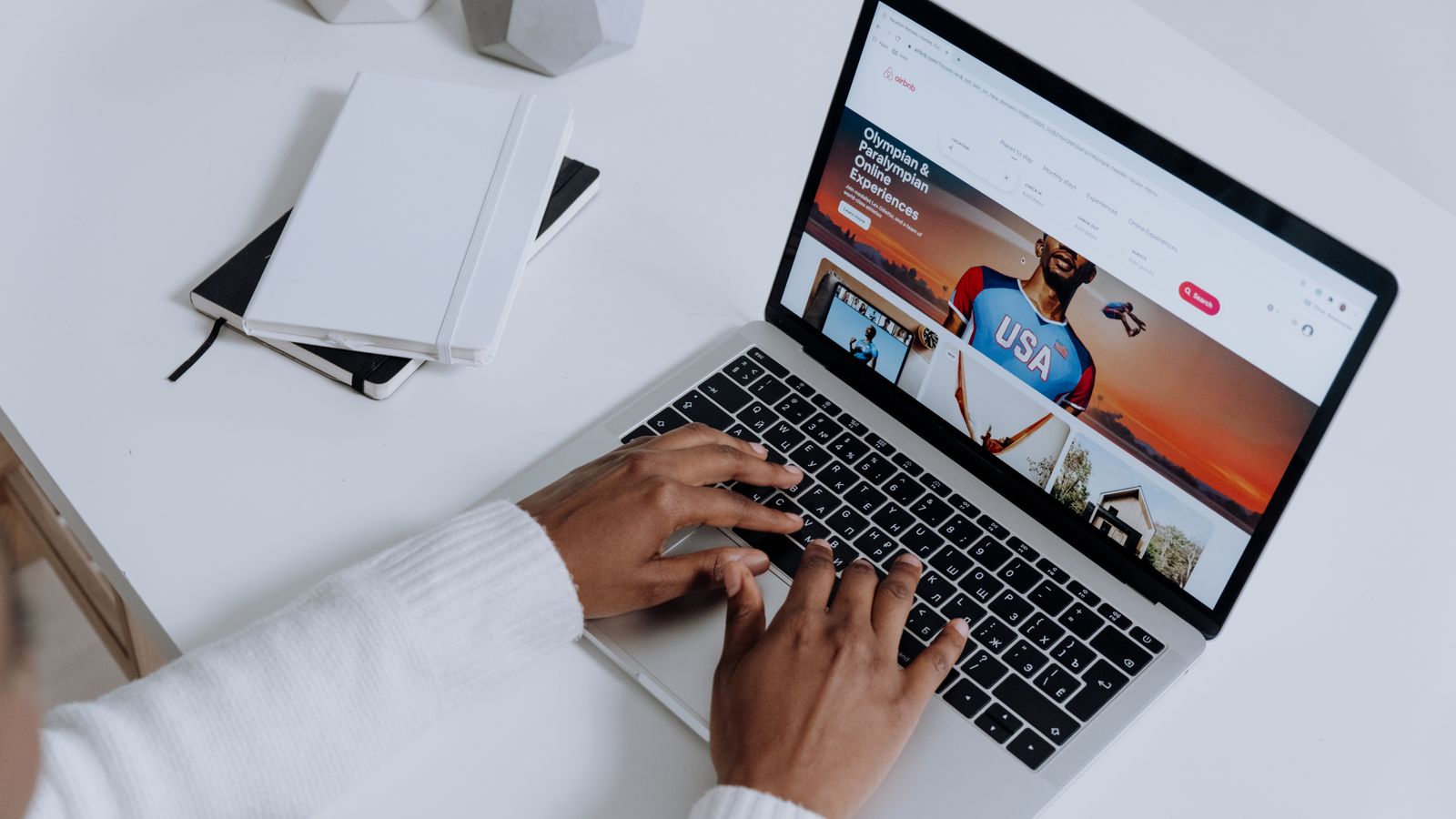Close-up of hands typing on a laptop in a modern workspace. Minimalist, clean aesthetic.