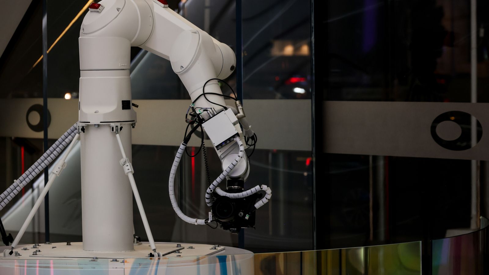 A white robotic arm operating indoors with a modern design and advanced technology.