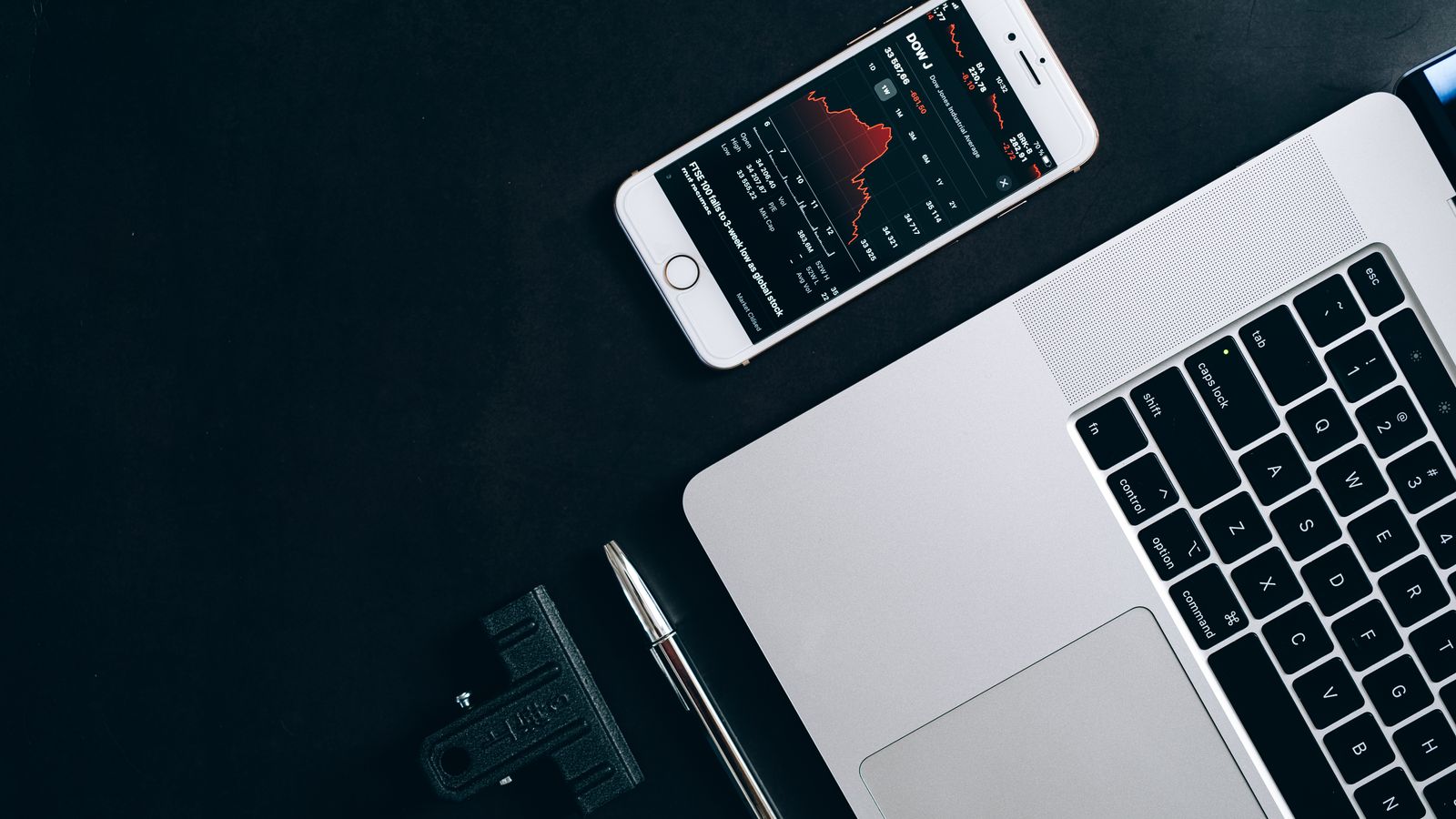 Modern workstation setup showcasing laptop, smartphone, and financial data for business use.